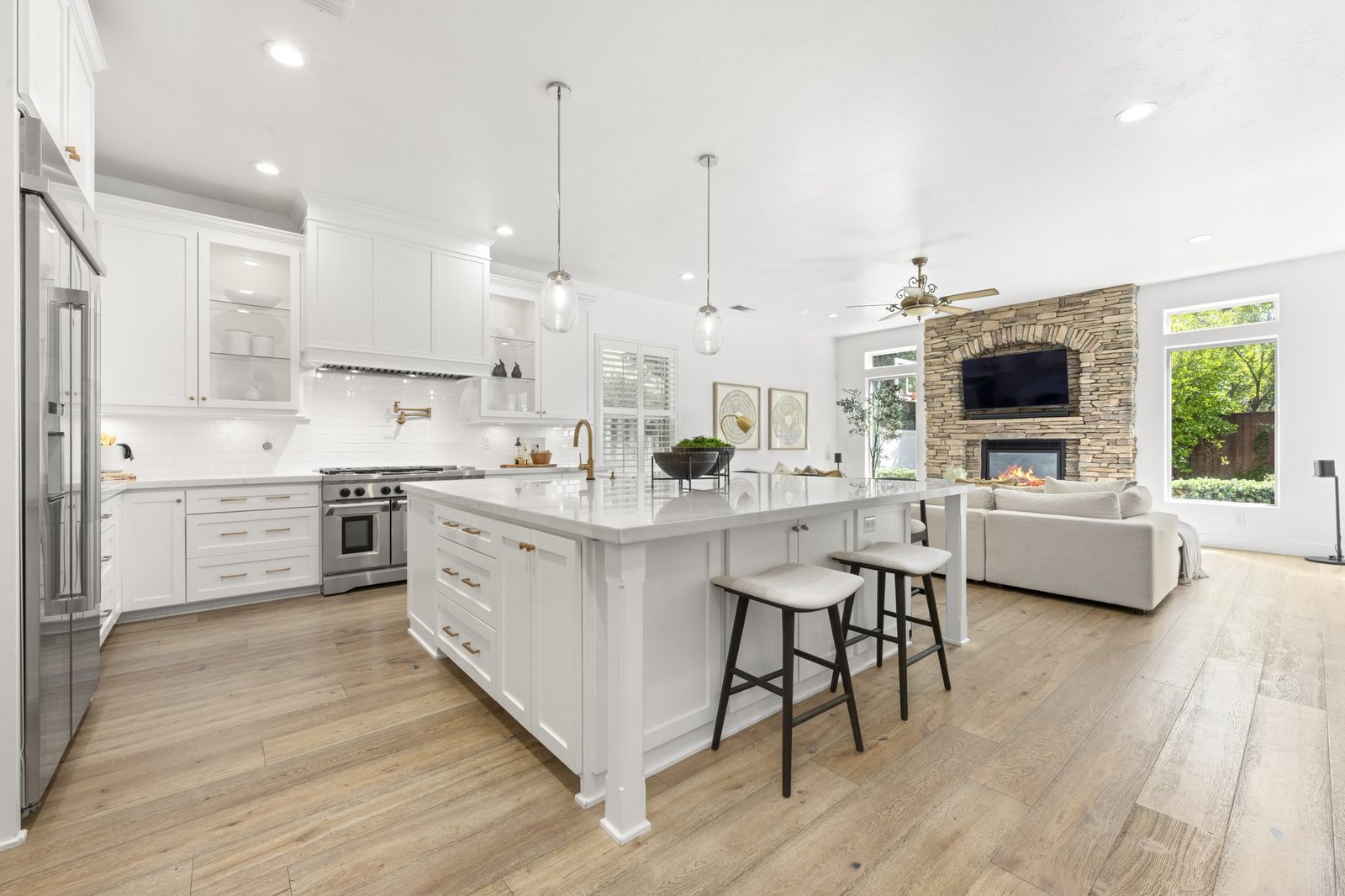 The kitchen island, open through to the great room and the stone fireplace