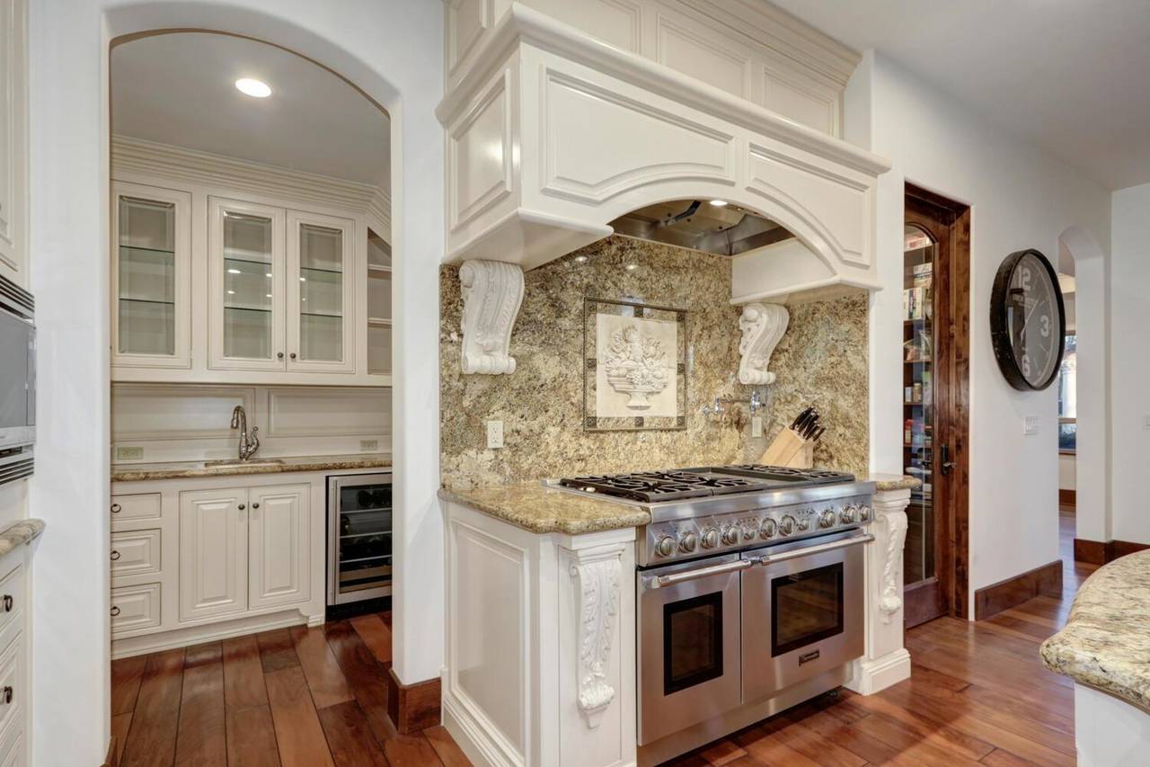The kitchen, with a professional range and a stone backsplash
