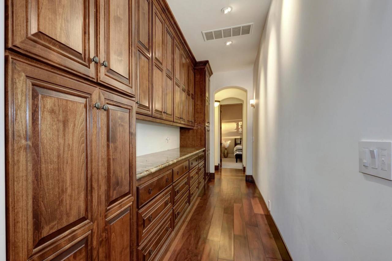 A hallway lined with built-in wood cabinetry